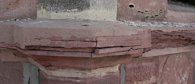 Hier ein Gesims, das die Basis einer Säule bildet.
Auch hier sind schon Teile des Sandsteines abgebrochen.
Tiefe Risse durchziehen den Sandstein.
