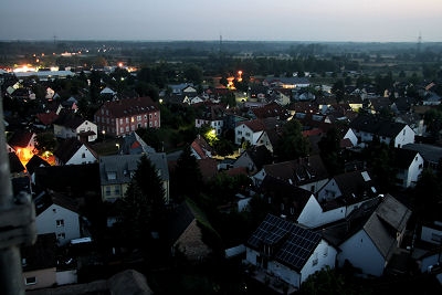 Zu sehen ist das alte Pfarrhaus und das alte Schulhaus in Mörsch. Links hinten sind die Lichter von Neuburgweier zu sehen.