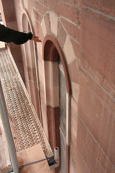 Hier werden die sanierten Fensterlaibungen begutachtet.

Auffällig ist, dass der Farbunterschied zwischen den neuen Sandsteinelementen und den mit Dichtschlämme sanierten Steinen zu groß ist.

Hier muss eine zweite Schicht Dichtschlämme aufgetragen werden, deren Farbgebung besser zu den Sandsteinen passt.

